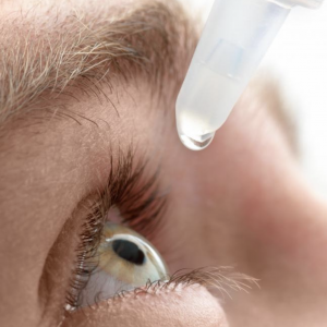 eyedrops above a person's open eye 