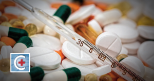 A close-up of prescription medication pills with a thermometer placed on top, illustrating the importance of keeping medications away of heat and high temperatures.